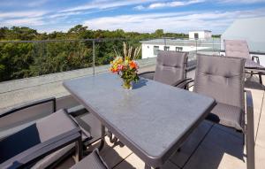 a table and chairs on a balcony with a vase of flowers at Prora Solitaire Avida Loft15 in Binz +41 photos
