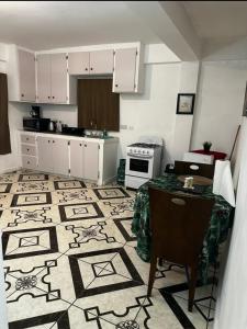 uma cozinha com armários brancos e piso em azulejo em Spacious Home away from Home! 1 Bedroom em Kingstown