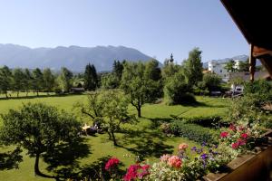Blick auf einen Park mit Blumen und Bäumen in der Unterkunft Ferienwohnungen im Alpengästehaus Marzoll - Bad Reichenhall in Bad Reichenhall