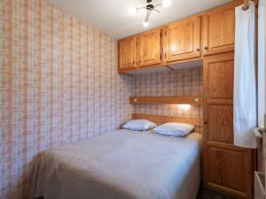 a small bedroom with a bed and wooden cabinets at Charmant T2 cabine 3 pers, balcon, parking privé, Luz-Saint-Sauveur - FR-1-402-139 in Esquièze - Sère