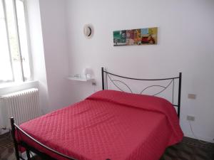 una camera con un letto con una coperta rossa di B&B Piccolo Lago a Travedona