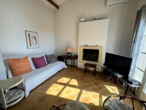 un salon avec un canapé et une télévision dans l'établissement Maison Individuelle 2 Chambres avec Jardin, Piscine et Tennis, Proche du Centre-Village - FR-1-726-44, à La Croix-Valmer