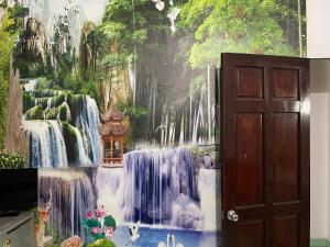 a wall with a painting of a waterfall at Khách sạn Hoàng Bảo Hùng in Ho Chi Minh City