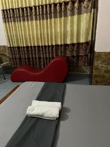 a towel sitting on a bed in front of a curtain at Khách sạn Hoàng Bảo Hùng in Ho Chi Minh City