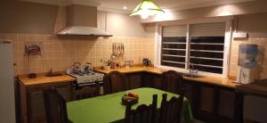 una cocina con una mesa verde en el medio. en Casa de Campo El Duraznillo en Tandil