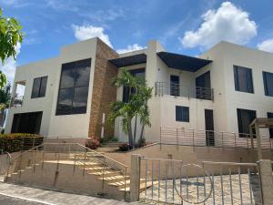 a large white building with a palm tree in front of it at Casa Lagos del Peñon in Girardot