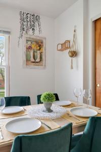a dining room table with white plates and chairs at Cozy Getaway for Long-Term Stays in Westmont