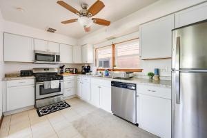 a kitchen with white cabinets and a ceiling fan at Curated for Cozy Longer Stays in Westmont