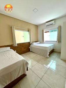 een slaapkamer met 2 bedden en een groot raam bij Casa em Paripueira, conforto e privacidade in Paripueira