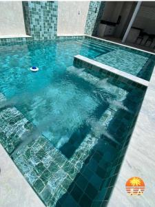 een groot zwembad met blauw water bij Casa em Paripueira, conforto e privacidade in Paripueira