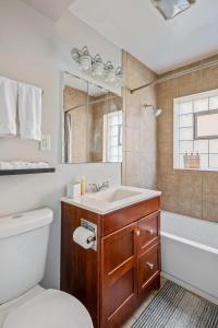 un bagno con lavandino, WC e vasca di Harmony Haven a Westmont Altre 13 foto