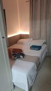 a pair of beds in a room with a window at Loft em prédio frente mar in Balneário Camboriú