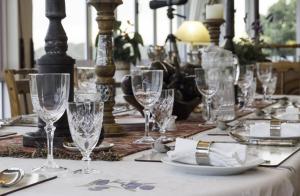 a table with glasses and plates on a table at Hillscapes Guesthouse in Port Alfred