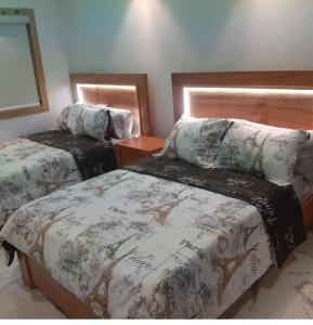 een slaapkamer met 2 bedden en een houten hoofdeinde bij Villa Génesis in Cabrera