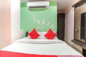 a bedroom with a white bed with red pillows at SPOT ON Hotel Sunshine Inn in Hyderabad