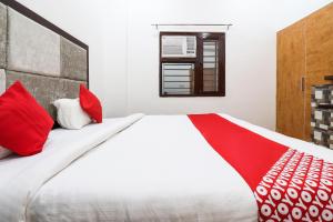 a bedroom with a large bed with red pillows at Super OYO Taj Royal in Tājganj