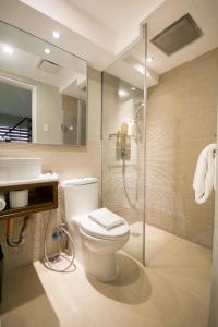 uma casa de banho com um WC, um chuveiro e um lavatório. em Boracay Haven Resort em Boracay