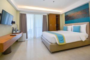 een hotelkamer met een groot bed en een televisie bij Boracay Haven Resort in Boracay