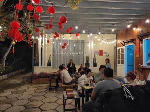 a group of people sitting at tables in a restaurant at IZA Homestay in Trai Mat