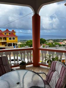 a balcony with a table and chairs and a view of the ocean at Hellshire Heights in Boscobel