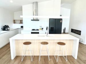 a kitchen with a white counter and two stools at Kinloch Lake View in Kinloch