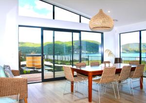 a dining room with a table and chairs and large windows at Kinloch Lake View in Kinloch