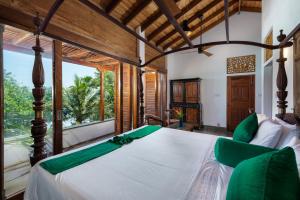 a bedroom with a large bed with green accents at Royal Indigo Villa in Talpe
