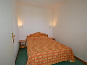 Dormitorio pequeño con cama y cruz en la pared en Appartement Saint-François-Longchamp, 2 pièces, 6 personnes - FR-1-635-140 en Saint-François-Longchamp