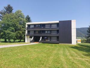 奥特朗Appartement rénové 4 pers, proche pistes, balcon sud, Autrans - FR-1-737-80的一座大楼，前面有一片草地