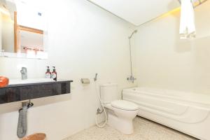 een witte badkamer met een toilet en een bad bij Paradis Hotel Quy Nhon in Quy Nhon