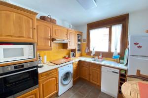 a kitchen with wooden cabinets and a washer and dryer at 06BP - Beautiful 6-person apartment in Valberg in Valberg