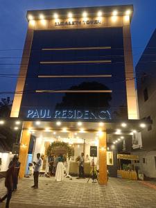 people standing outside of a building at night at PAUL RESIDENCY in Nedumbassery