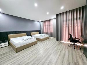 sypialnia z 2 łóżkami i krzesłem w obiekcie Le Luxe Home - Vinhomes Marina tại Lê Chân w Hajfong