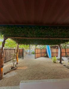 a blue surfboard sitting under a pergola at Frente la playa Isis in Sámara