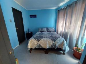 - une chambre bleue avec un lit et un mur bleu dans l'établissement Departamento En Centro Turístico De Valparaíso, à Valparaíso