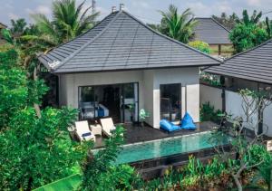 BedahuluにあるCapung Asri Eco Luxury Resort with Private Pool Villasの椅子とポーチ付きの家屋の空中風景