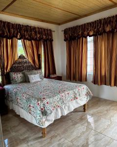 a bedroom with a large bed in a room with windows at Hellshire Heights in Boscobel