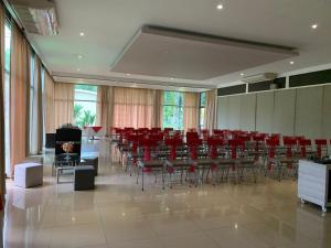 uma sala de conferências com cadeiras vermelhas e mesas em Hotel Los Rios em Guácimo