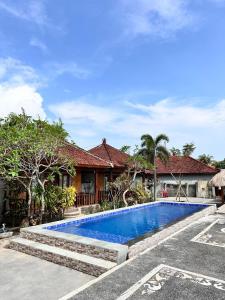 a swimming pool in front of a house at Krisna Bungalows and Restaurant in Sekotong