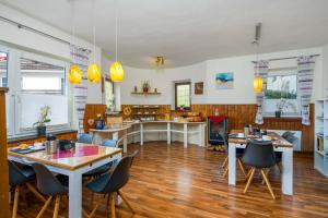 a room with tables and chairs and a kitchen at Pension Bayerwald in Bodenmais