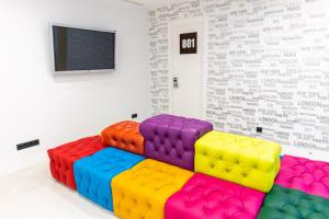 um quarto com um sofá colorido em frente a uma parede em Hostal Charlotte-Gran Vía em Madrid