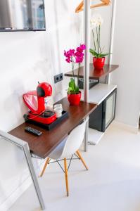 a desk with flowers and a red appliance on it at Hostal Charlotte-Gran Vía in Madrid