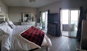 a bedroom with a bed and a fireplace and a television at EdgeWater Chemainus in Chemainus