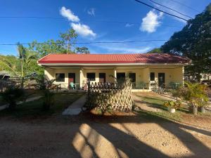 a small yellow house with a red roof at Noah Xye Guest House in San Juan