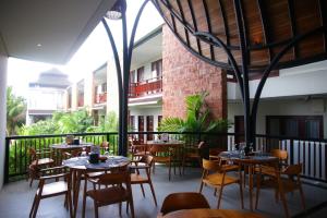 a restaurant with tables and chairs on a balcony at djabu Seminyak Hotel in Seminyak