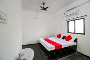 a white bedroom with a bed and a sink at OYO Flagship 69410 Sip & Bite Restaurant N Lodging in Mansar