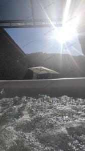 a sun shining over a swimming pool with an umbrella at Appartement meublé classé 3 étoiles de 72 m2, 2 chambres in Morzine
