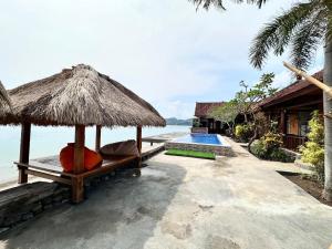 a resort with a swimming pool and a straw umbrella at Krisna Bungalows and Restaurant in Sekotong