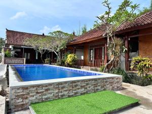 a swimming pool in front of a house at Krisna Bungalows and Restaurant in Sekotong