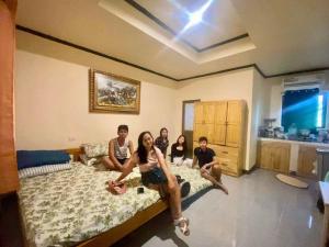 a group of people sitting on a bed at Noah Xye Guest House in San Juan